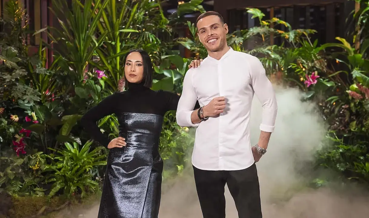 Two judges from MasterChef Dessert Masters Italia stand in front of a lush green backdrop with smoke effects.