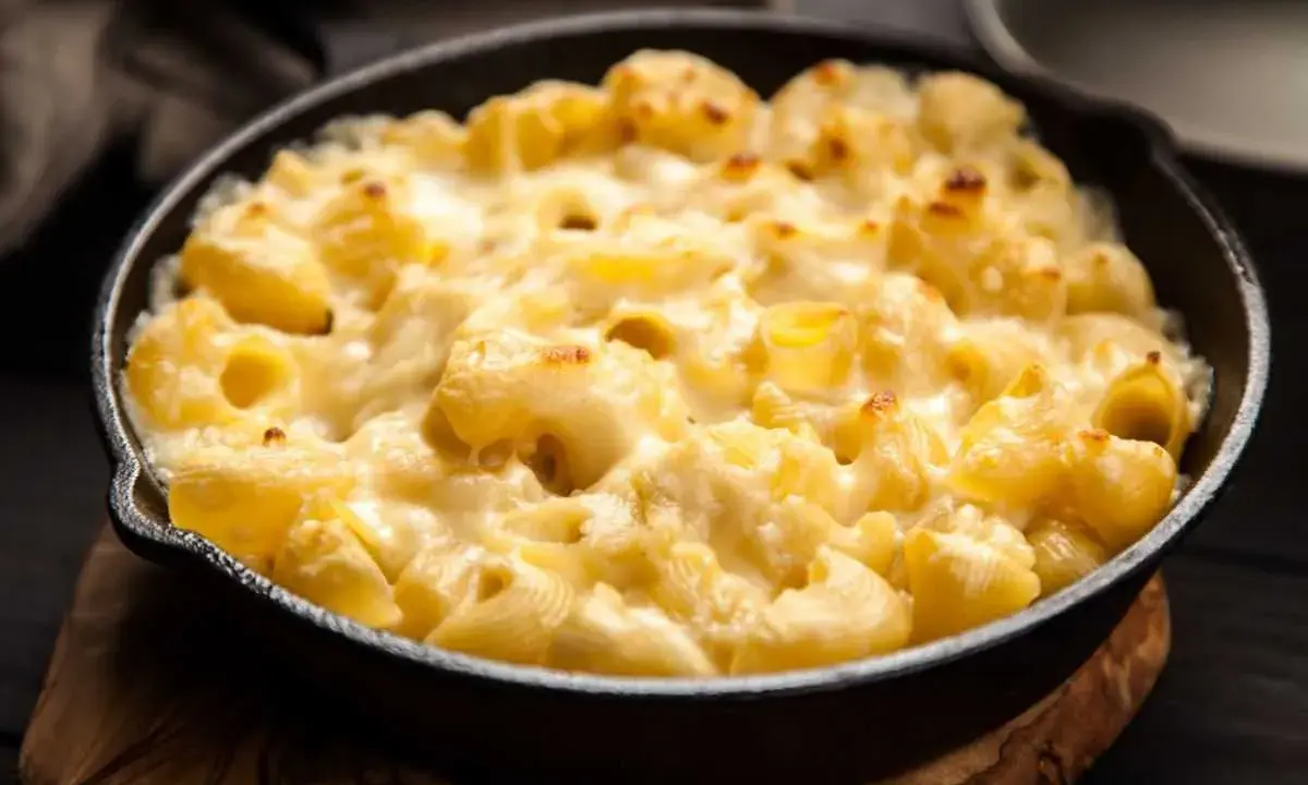 Baked pasta with creamy cheese sauce in a cast iron skillet.