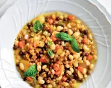 A hearty bowl of farro soup with white beans, lentils, carrots, and basil.