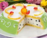 A slice of green marzipan-covered Cassata Siciliana cake with candied fruit and chocolate chips.