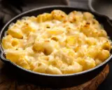 Baked pasta with creamy cheese sauce in a cast iron skillet.