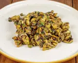 Grilled eggplant salad with capers and herbs on a white plate.