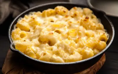 Baked pasta with creamy cheese sauce in a cast iron skillet.