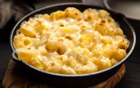 Baked pasta with creamy cheese sauce in a cast iron skillet.
