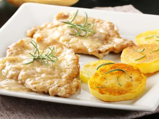 Two breaded cutlets in creamy sauce with rosemary, served with pan-fried potato slices.