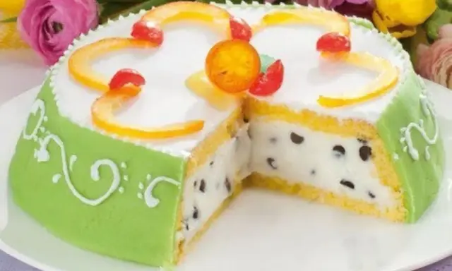 A slice of green marzipan-covered Cassata Siciliana cake with candied fruit and chocolate chips.
