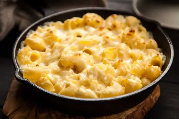 Baked pasta with creamy cheese sauce in a cast iron skillet.